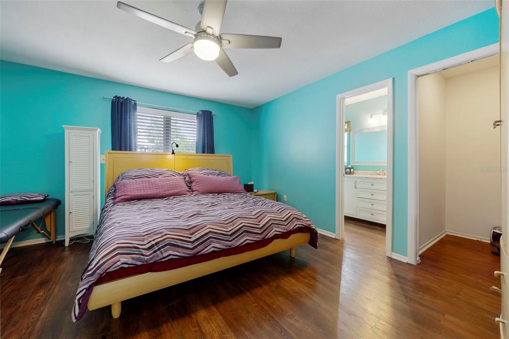 818 Eunice Drive Tarpon Springs, FL 34689 - Photo 16 of 59 a bedroom with a bed and a chandelier