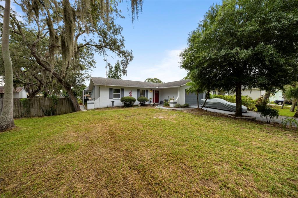 818 Eunice Drive Tarpon Springs, FL 34689 - Photo 2 of 59 a front view of a house with a garden