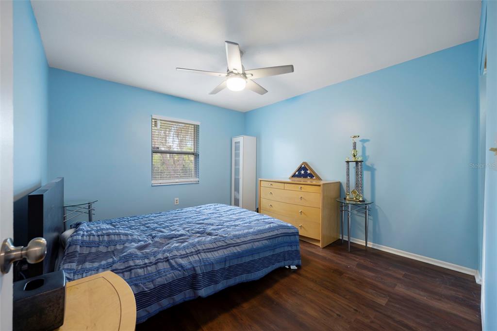 818 Eunice Drive Tarpon Springs, FL 34689 - Photo 22 of 59 a bedroom with a bed and a dresser in it