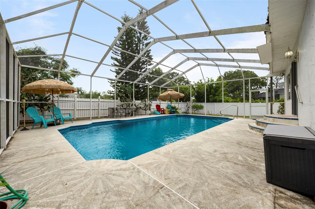 818 Eunice Drive Tarpon Springs, FL 34689 - Photo 28 of 59 a view of a swimming pool with a patio and a yard
