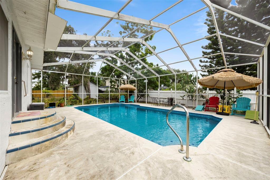 818 Eunice Drive Tarpon Springs, FL 34689 - Photo 29 of 59 a view of a swimming pool with a patio and a yard