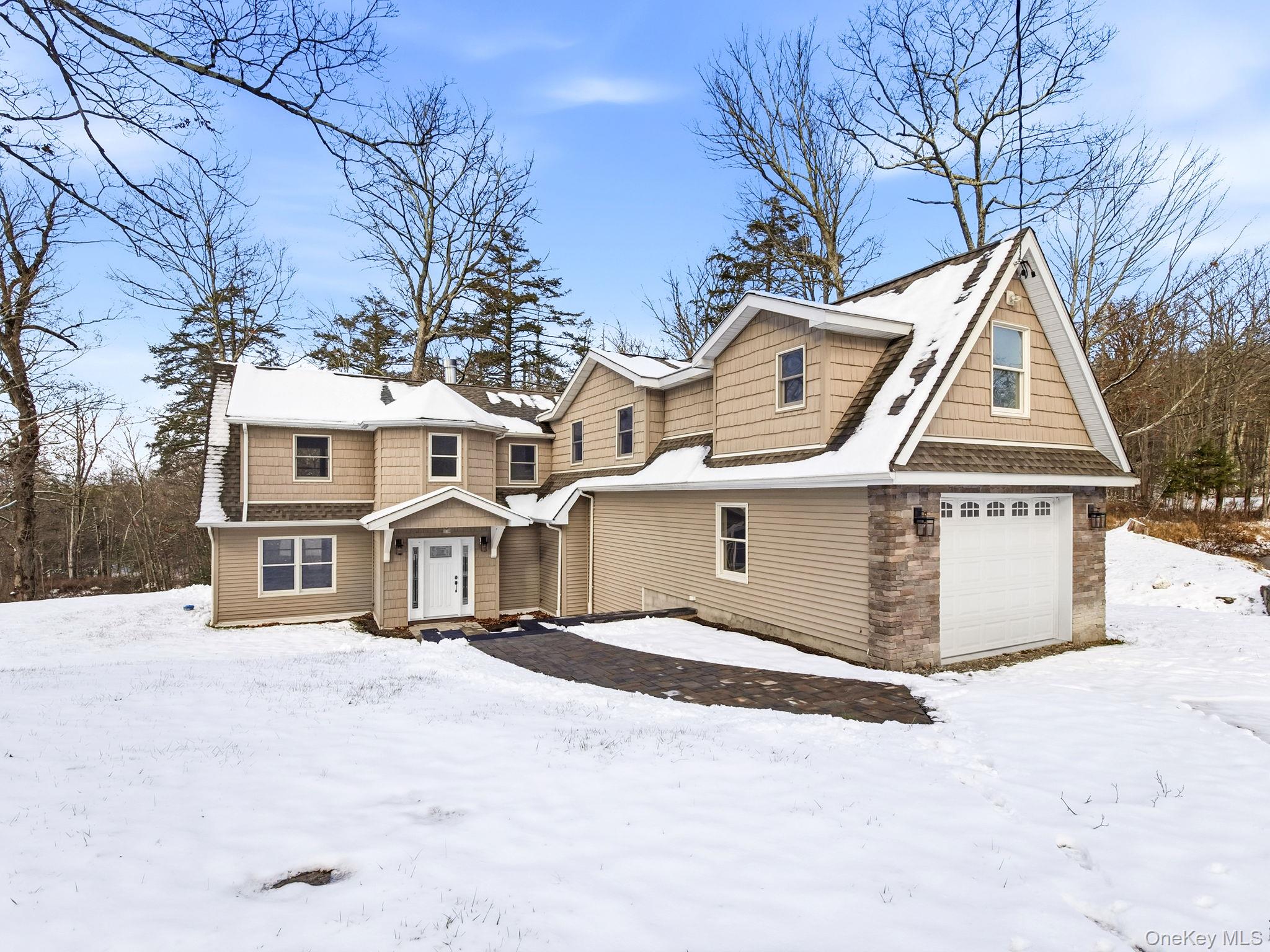 View of front of house with a patio and a garage