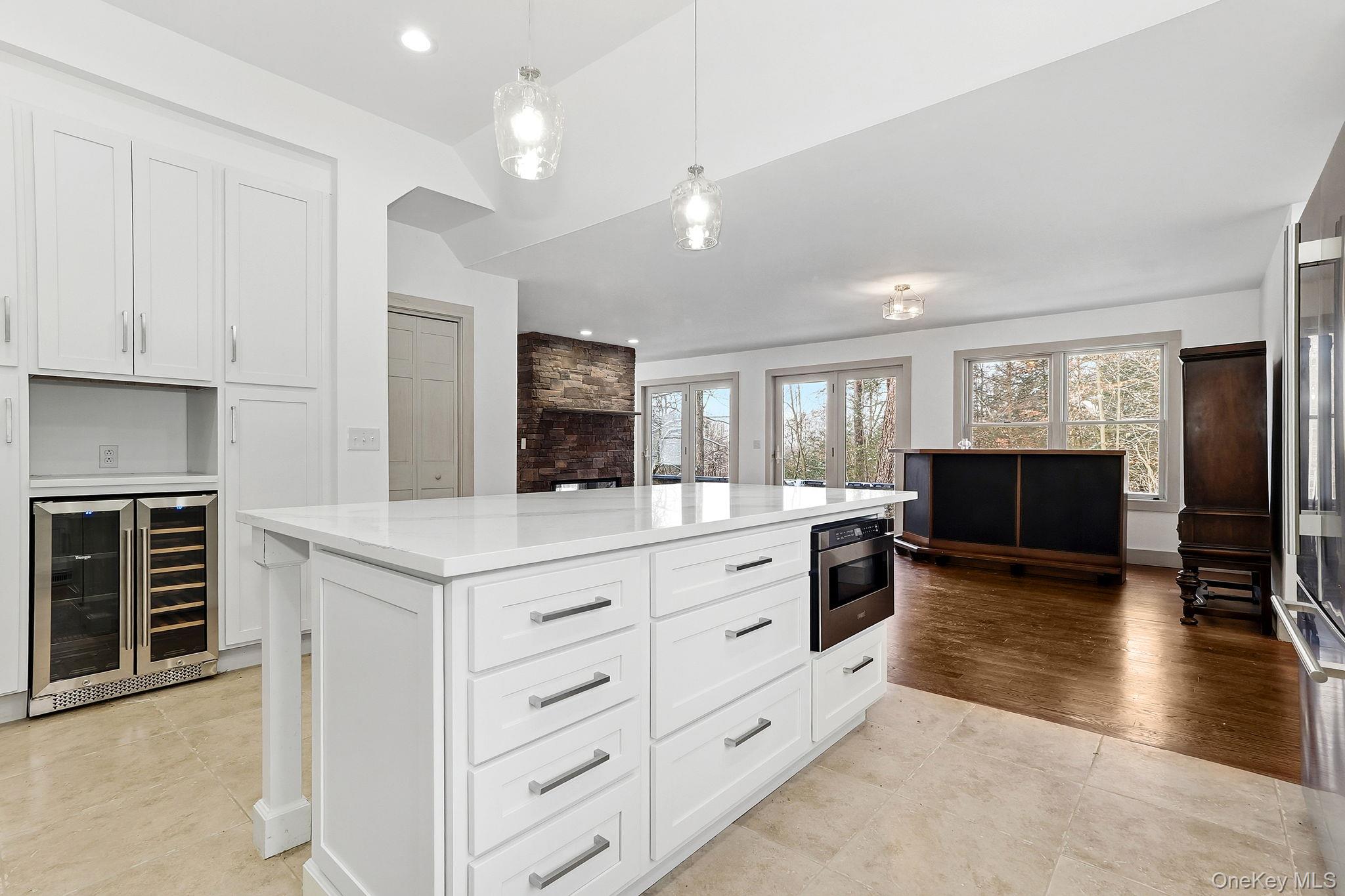 344 Schultz Hill Road Rhinebeck, NY 12572 - Photo 16 of 43 Kitchen with white cabinets, beverage cooler, pendant lighting, and a center island