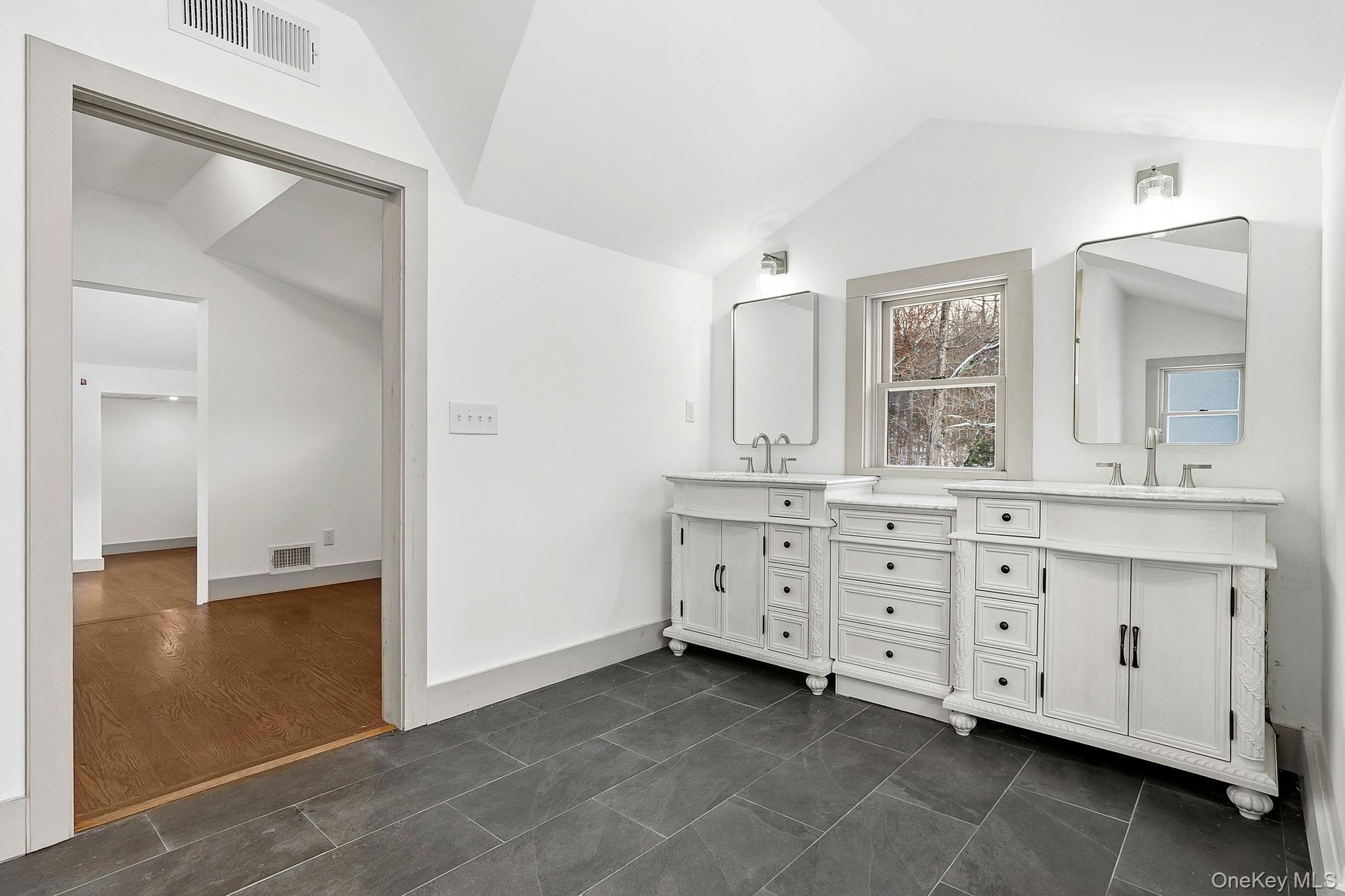 344 Schultz Hill Road Rhinebeck, NY 12572 - Photo 24 of 43 Bathroom featuring vaulted ceiling, double vanity, and dark tile patterned flooring