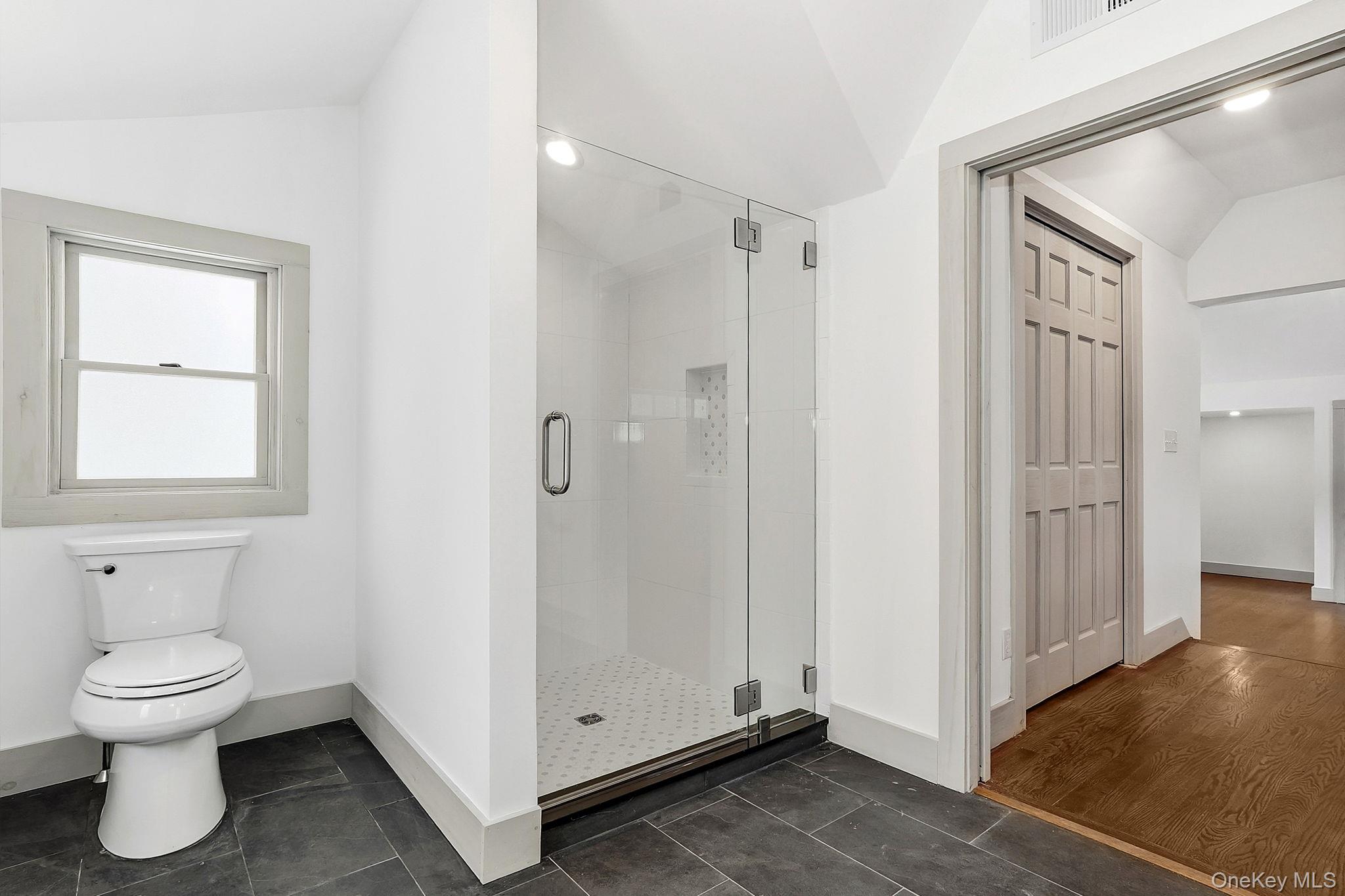 344 Schultz Hill Road Rhinebeck, NY 12572 - Photo 25 of 43 Bathroom with vaulted ceiling, a stall shower, and dark tile patterned floors