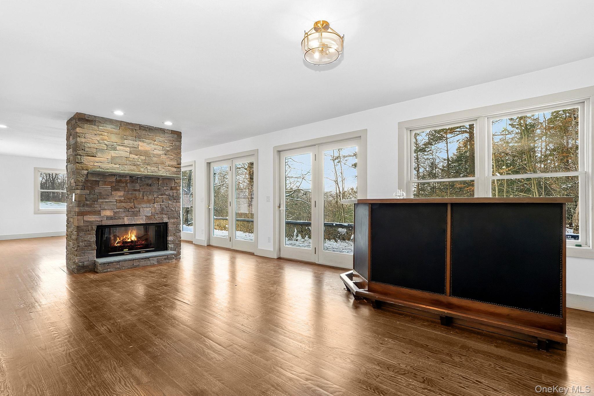 344 Schultz Hill Road Rhinebeck, NY 12572 - Photo 9 of 43 Unfurnished living room featuring a stone fireplace, wood finished floors, and recessed lighting