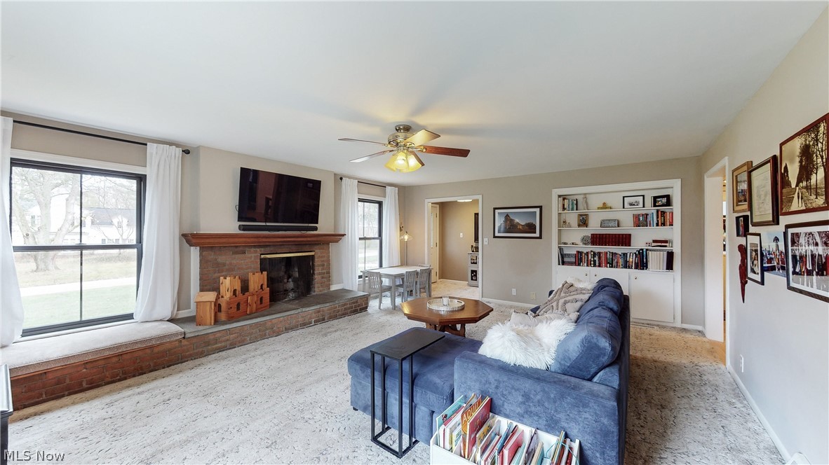 2386 Brice Road Akron, OH 44313 - Photo 21 of 41 Living room with light colored carpet, ceiling fan, a brick fireplace, and a healthy amount of sunlight