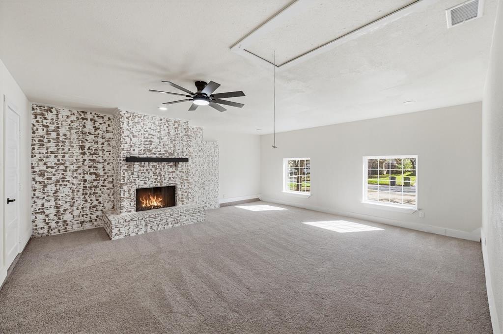 2804 Bent Tree Lane Arlington, TX 76016 - Photo 7 of 32 a view of a livingroom with a fireplace a ceiling fan and windows