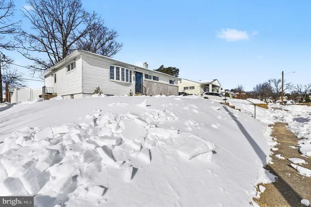 a front view of a house with a yard covered in snow