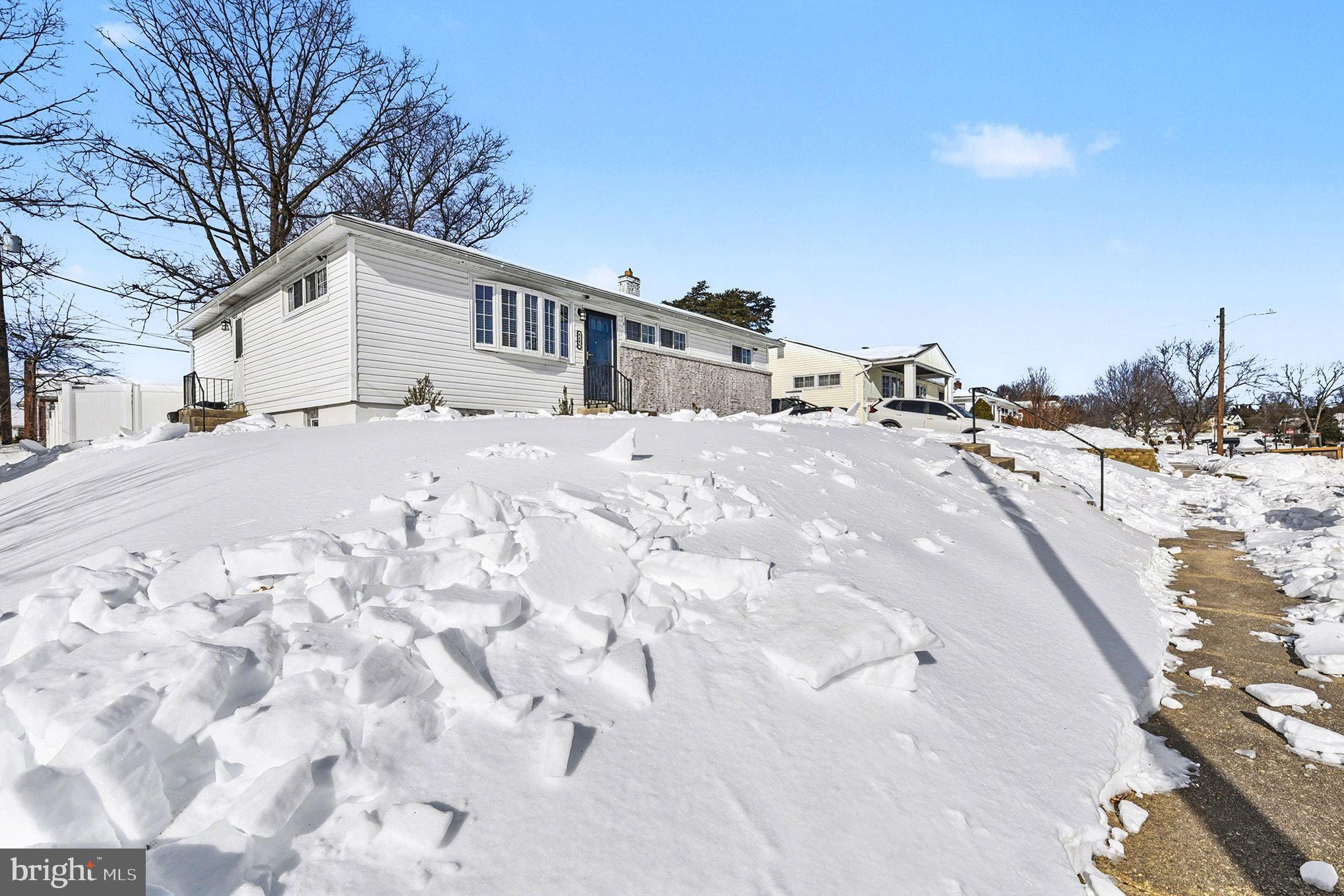 8806 Lakewood Road Parkville, MD 21234 - Photo 2 of 28 a front view of a house with a yard covered in snow