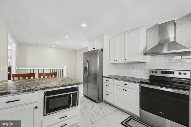 a kitchen with granite countertop stainless steel appliances and white cabinets