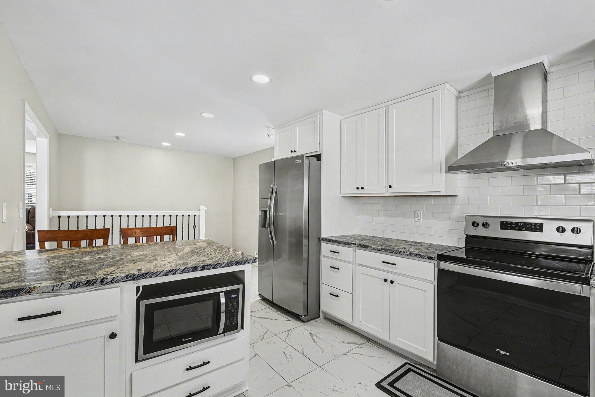 8806 Lakewood Road Parkville, MD 21234 - Photo 8 of 28 a kitchen with granite countertop stainless steel appliances and white cabinets