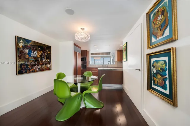 a view of a dining room with furniture and a painting on the wall