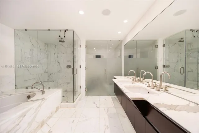 a bathroom with a double vanity sink large mirror and shower