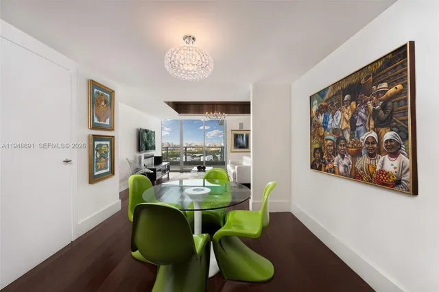 a view of a dining room with furniture a potted plant and wooden floor