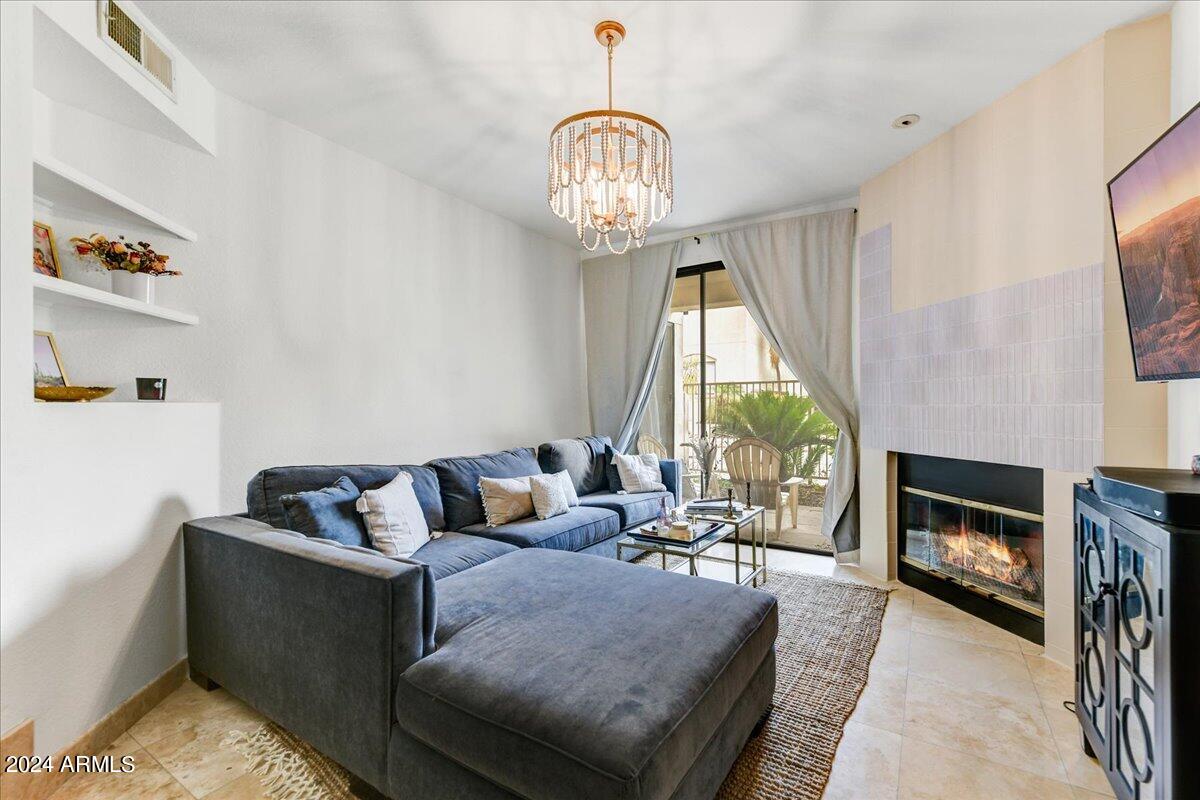 3235 East Camelback Road, Unit 109 Phoenix, AZ 85018 - Photo 6 of 20 a living room with furniture fireplace and a flat screen tv