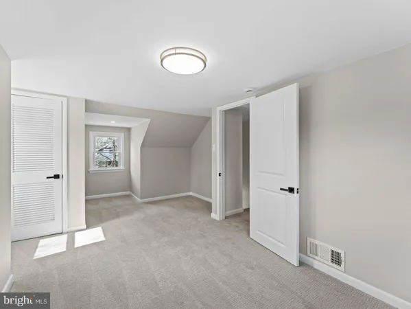 an empty room with closet area and bathroom