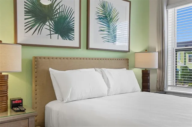 a bedroom with a large bed and a chandelier