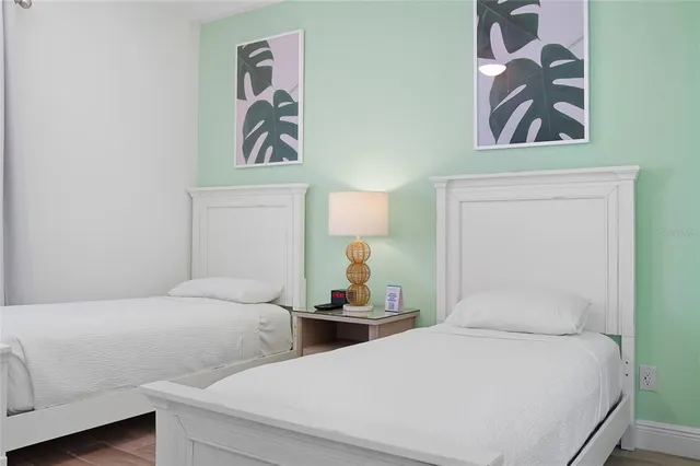 a bedroom with two beds and a chandelier