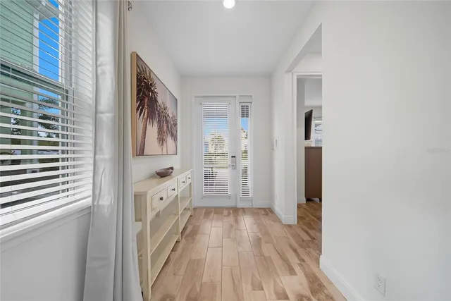 a view of hallway with wooden floor and cabinets