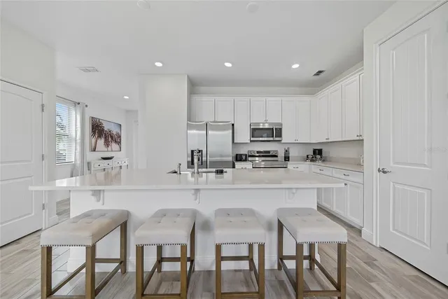 a kitchen with stainless steel appliances white cabinets and a sink