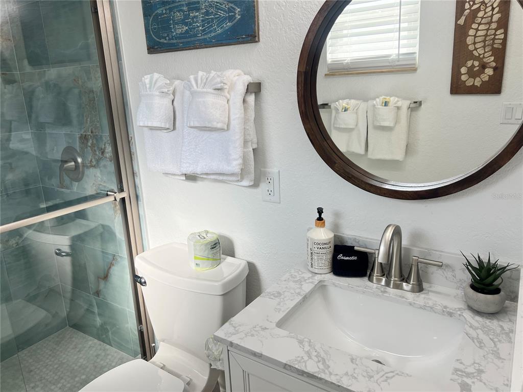 6154 Midnight Pass Road, Unit B16 Sarasota, FL 34242 - Photo 13 of 14 a bathroom with a toilet a sink and a mirror
