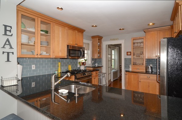 11 Hardy Road Wellesley, MA 02482 - Photo 6 of 20 a kitchen with stainless steel appliances granite countertop a refrigerator a stove and a sink with wooden floor