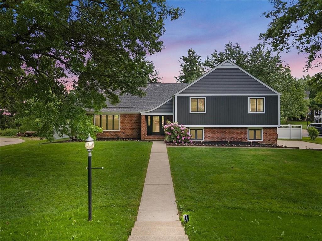 a front view of a house with a yard and trees