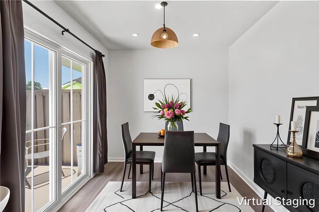 137 Nicklaus Drive Anderson, SC 29621 - Photo 10 of 37 A well-lit dining area featuring a sleek dark wood table, recessed lighting, and direct access to an outdoor patio.