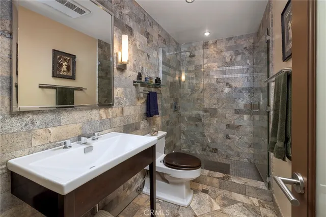 a bathroom with a sink toilet a mirror and shower