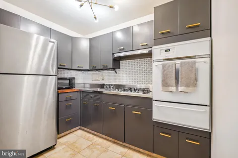 a kitchen with stainless steel appliances granite countertop a refrigerator and a stove