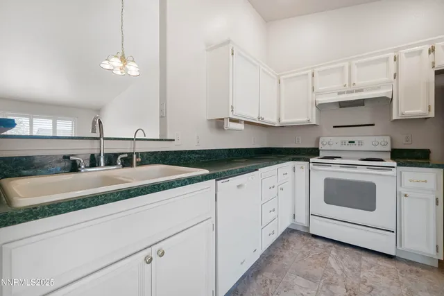 a kitchen with granite countertop white cabinets and white appliances