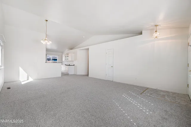 a view of a big room with chandelier fan and windows
