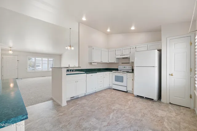 a kitchen with white cabinets and white appliances