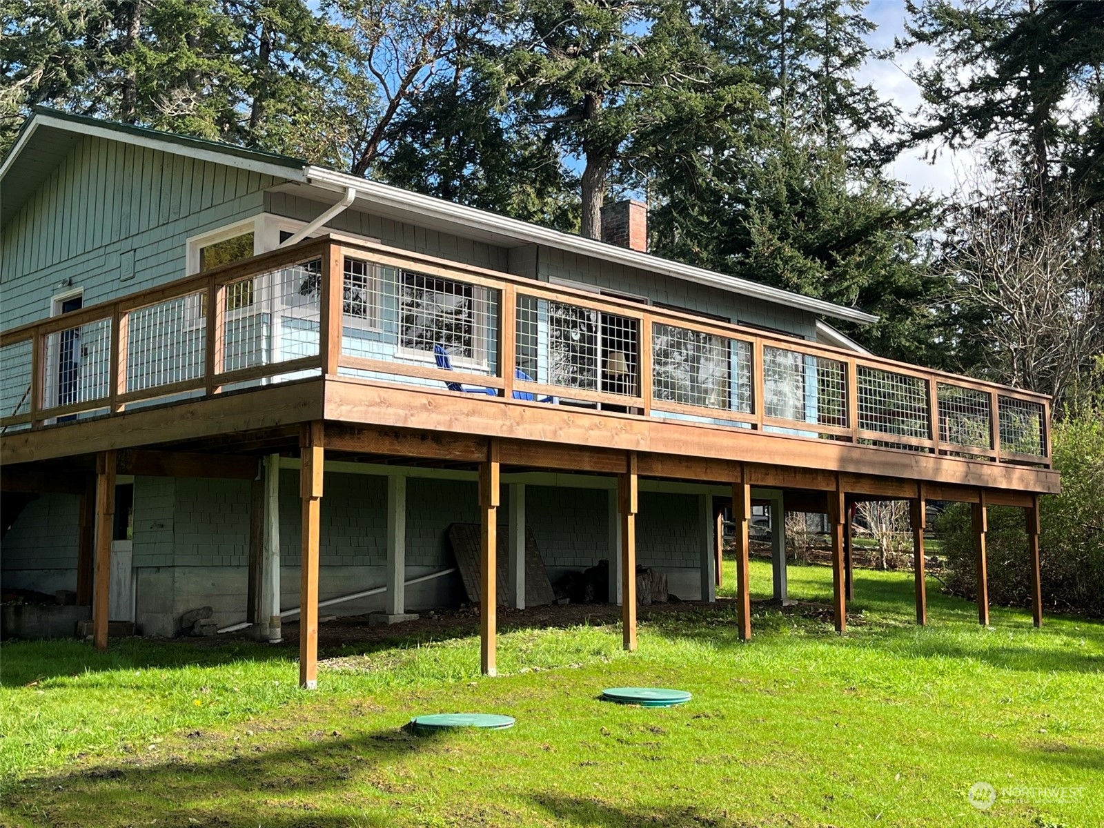 509 Spring Street Camano Island, WA 98282 - Photo 3 of 28 a backyard of a house with lawn chairs and a yard with swimming pool