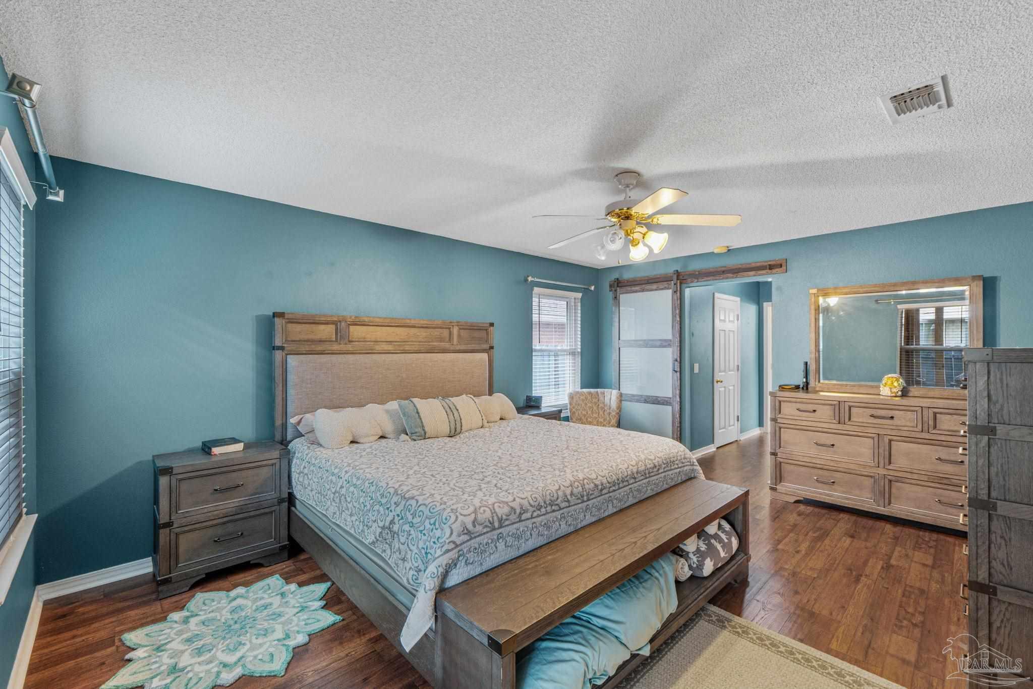 1739 Ivalea Circle Navarre, FL 32566 - Photo 30 of 46 a bedroom with a large bed and a chandelier