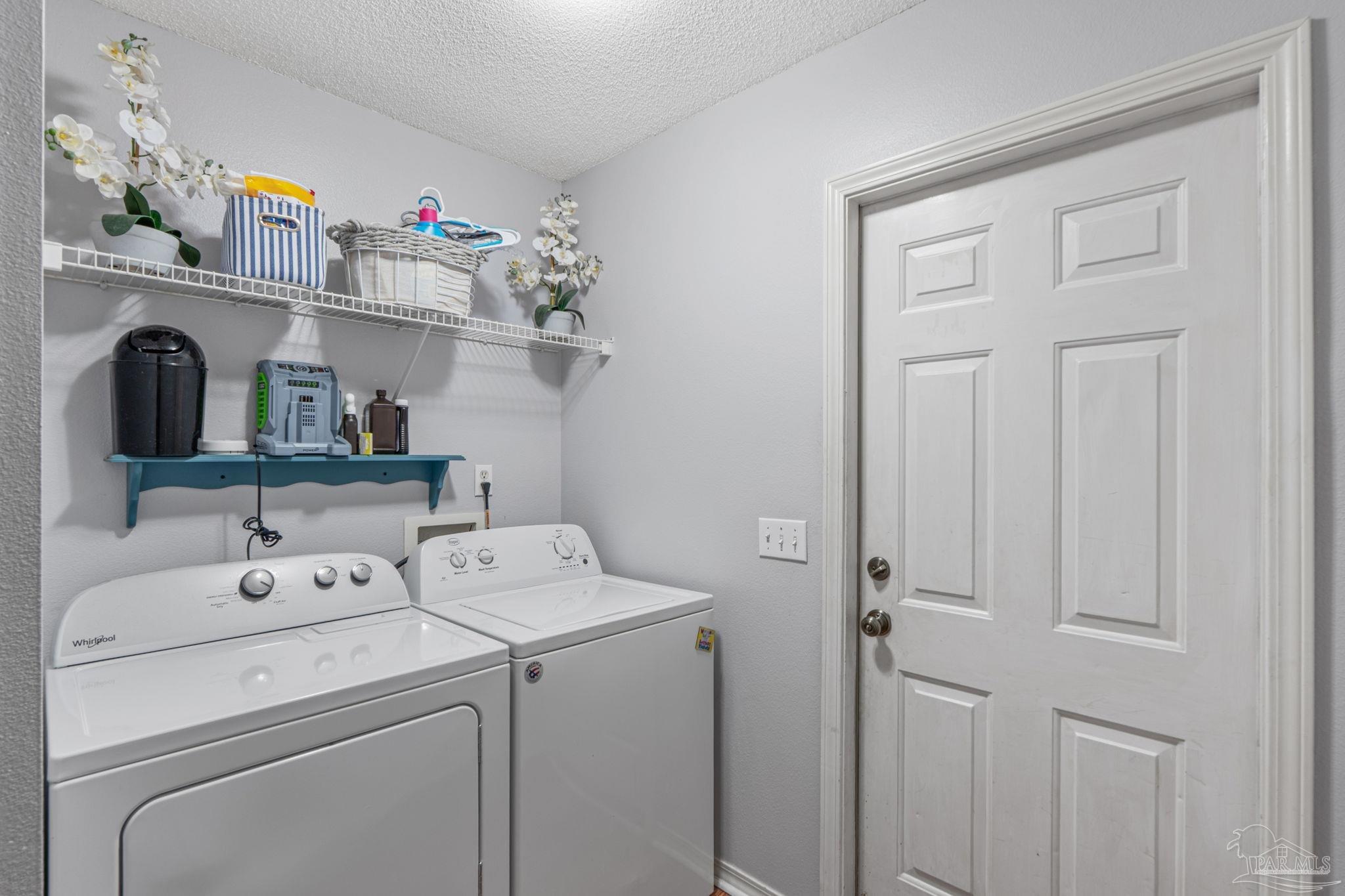 1739 Ivalea Circle Navarre, FL 32566 - Photo 42 of 46 a view of washer and dryer with kitchen in the background