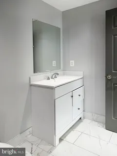 a utility room with a sink a vanity and a mirror