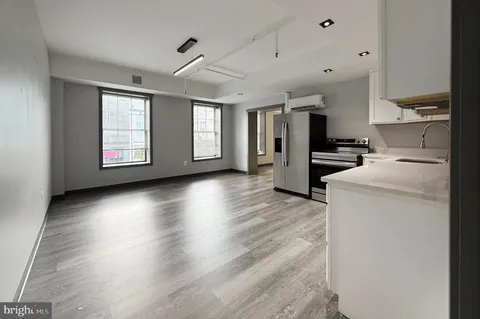 a view of a kitchen with fridge and wooden floor