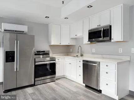 a kitchen with stainless steel appliances white cabinets a stove a sink and a microwave