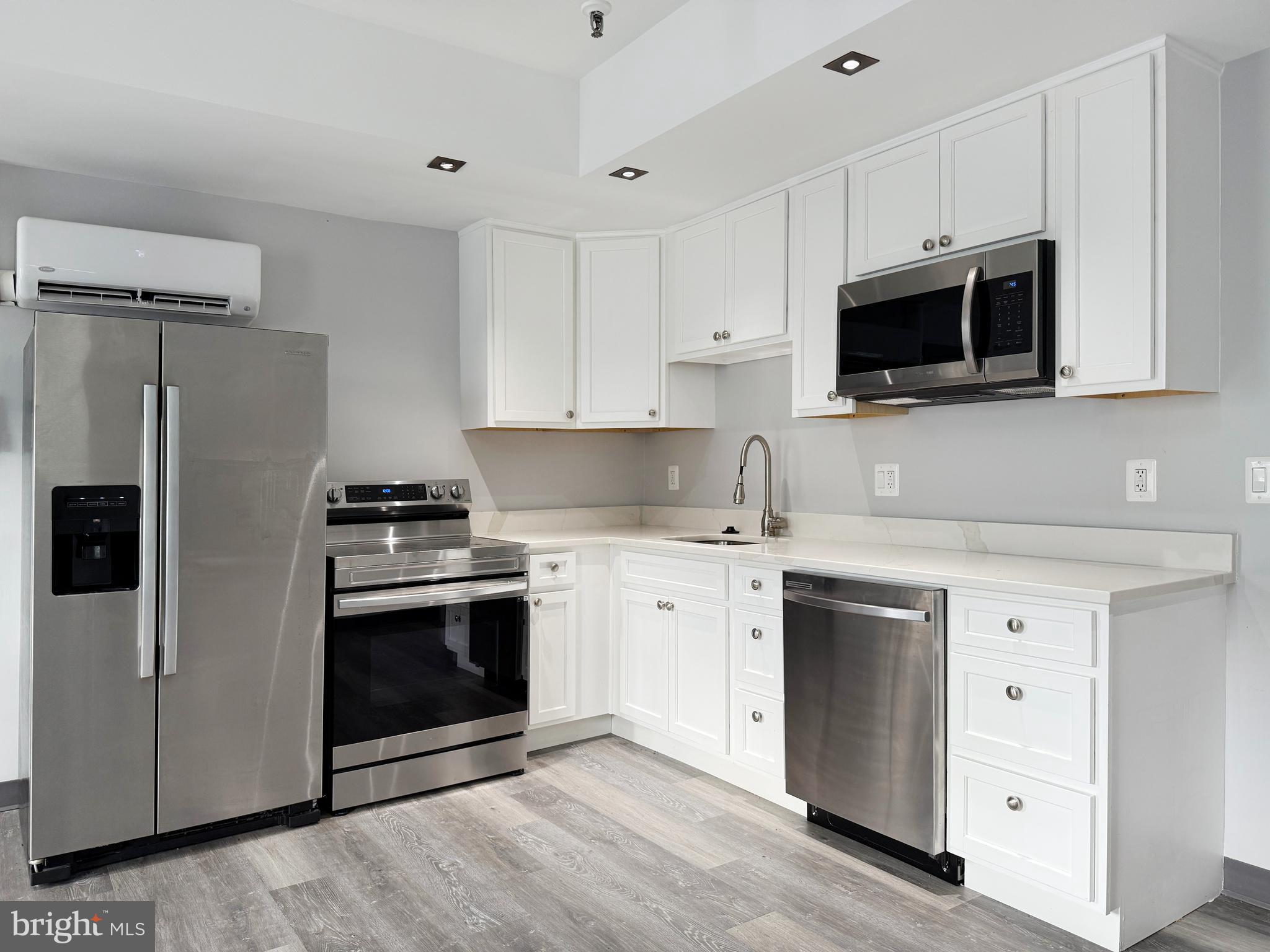 1365 Wisconsin Avenue Northwest, Unit 2 Washington, DC 20007 - Photo 7 of 14 a kitchen with stainless steel appliances white cabinets a stove a sink and a microwave