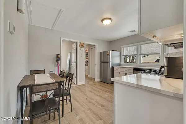 a kitchen with refrigerator and chairs