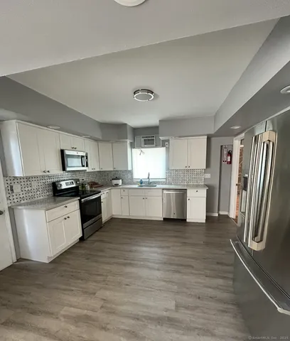a large kitchen with a white stove top oven and refrigerator