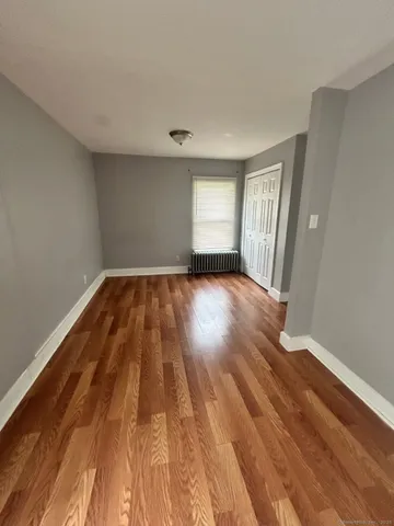 a view of a room with wooden floor and window