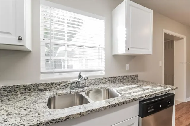 a kitchen with granite countertop a sink and a window