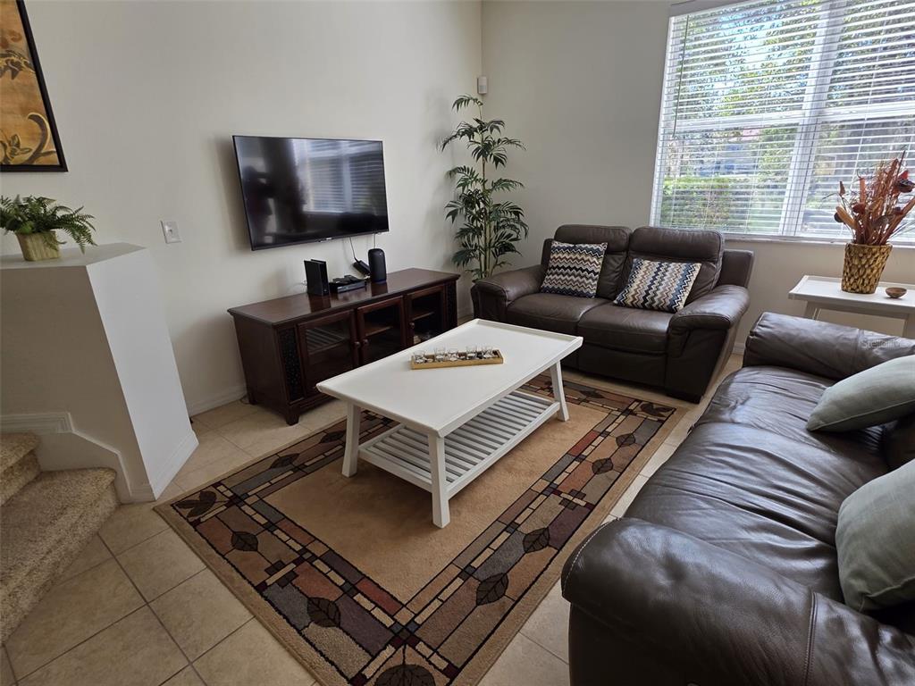 5160 Ambergris Loop Kissimmee, FL 34746 - Photo 12 of 38 a living room with furniture and a flat screen tv