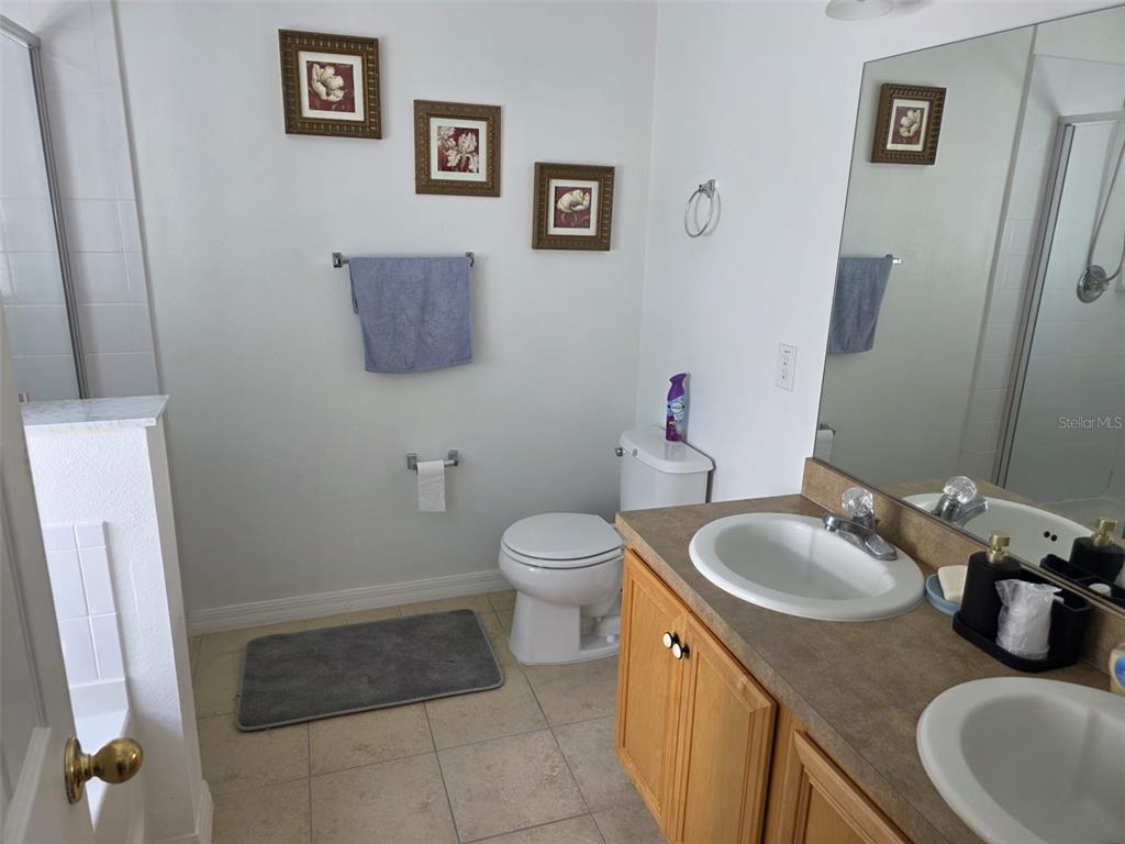 5160 Ambergris Loop Kissimmee, FL 34746 - Photo 27 of 38 a bathroom with a sink a toilet and a mirror