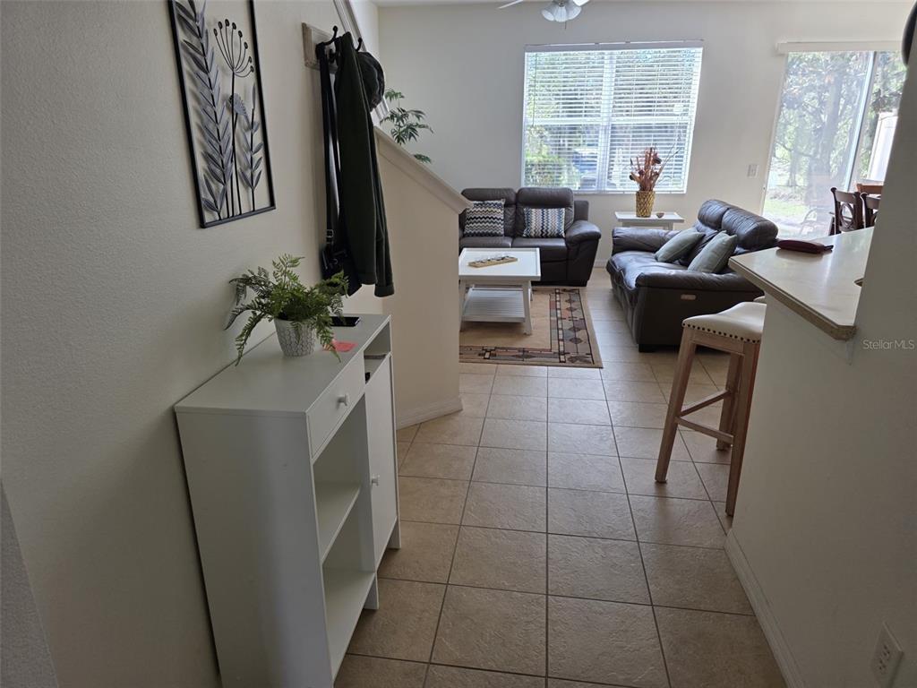 5160 Ambergris Loop Kissimmee, FL 34746 - Photo 5 of 38 a living room with furniture a chandelier and a flat screen tv