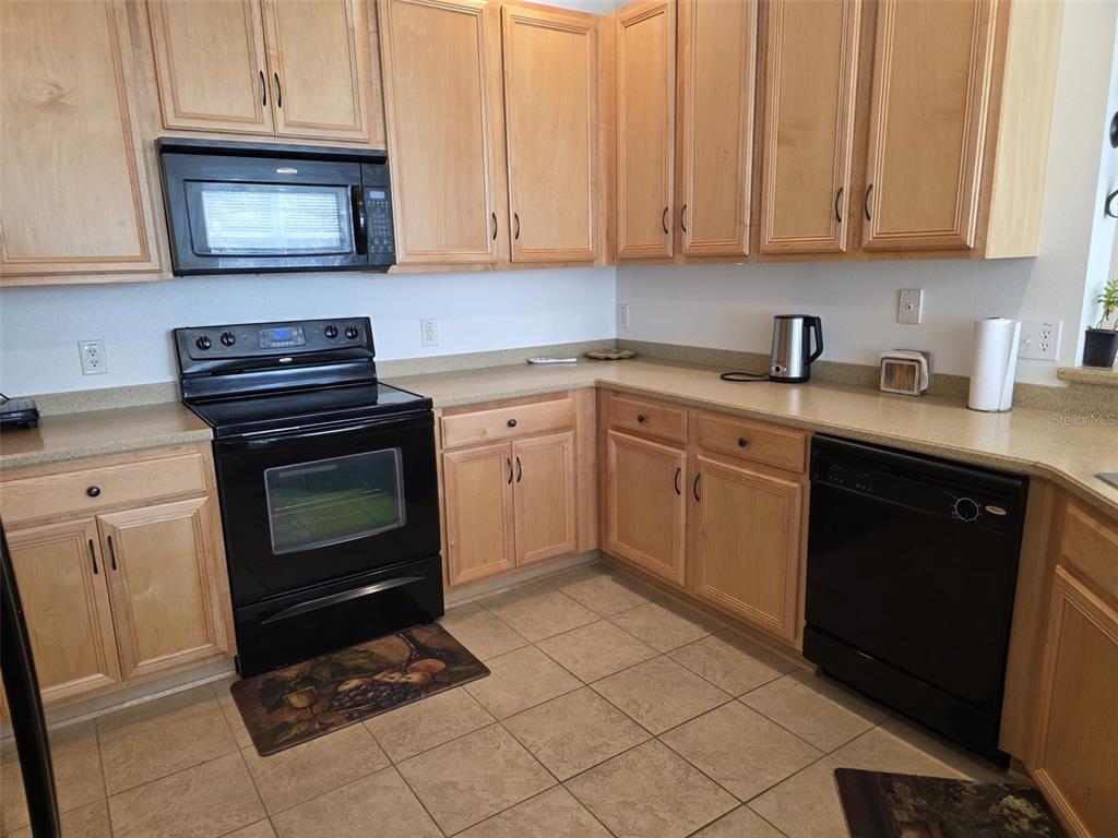 5160 Ambergris Loop Kissimmee, FL 34746 - Photo 7 of 38 a kitchen with cabinets a sink and a stove