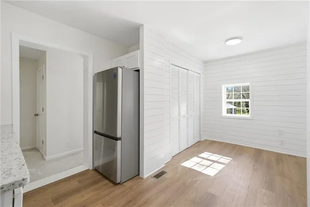 a view of empty room with wooden floor and window
